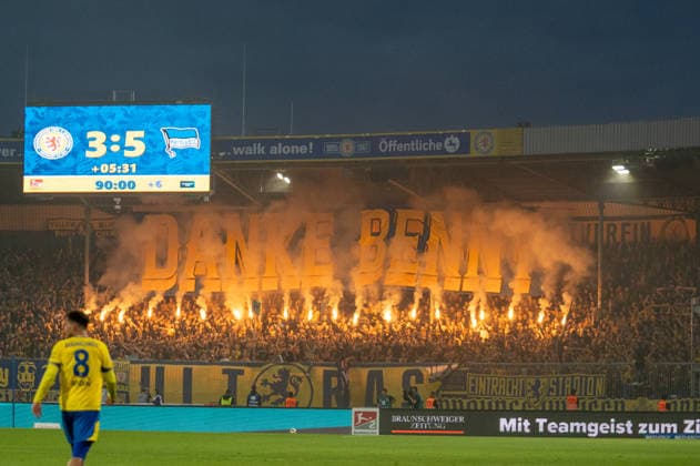 Deutschland: Fussball 2. Bundesliga, 3. Spieltag 2026 2027, Eintracht Braunschweig - Hertha BSC am 28.08.2026 in Braunschweig (Eintracht-Stadion): Fans von Eintracht Braunschweig zünden Pyrotechnik im Fanblock. Choreografie mit Danke Benny ist zu lesen. Eintracht Braunschweig, BTSV, Braunschweig, Eintracht, Fußball, Fussball, Fans, Fußballfans, Fussballfans, Anhänger, Ultras, Fanszene, Fankultur, Fanblock, Fankurve, Kurve, Tribüne, Pyrotechnik, Pyro, Bengalo, Bengalos, Bengalisches Feuer, Leuchtfackel, Fackeln, Rauch, Rauchentwicklung, Rauchwolke, Stadion, Fußballstadion, Fussballstadion, Stadionanzeige, Videowand, Anzeigetafel, Bitte das Abbrennen von Pyrotechnik einstellen, Pyrotechnik Verbot, Verbot, Sicherheitswarnung, Sicherheit, Stadionordnung, Spielunterbrechung, DFB, Bundesliga, 2. Bundesliga, Profifußball, Profifussball, Fanschals, Fahnen, Fanflaggen, Stimmung, Stadionatmosphäre, Niedersachsen, Deutschland *** German Soccer 2. Bundesliga, Matchday 3, 2026–2027, Eintracht Braunschweig vs. Hertha BSC on August 28, 2026, at Eintracht Stadium in Braunschweig. Eintracht Braunschweig fans set off pyrotechnics in the fan section; a choreographed display reads Thank you, Benny. Eintracht Braunschweig, BTSV, Braunschweig, Eintracht, soccer, soccer, fans, soccer fans, supporters, ultras, fan scene, fan culture, fan section, fan curve, curve, stands, pyrotechnics, pyro, Bengalo, Bengalos, Bengal fire, flares, smoke, smoke development, smoke cloud, stadium, soccer stadium, soccer stadium, stadium display, video wall, scoreboard, Please stop setting off pyrotechnics, pyrotechnics ban, ban, safety warning, safety, stadium rules, game interruption, DFB, Bundesliga, 2. Bundesliga, professional soccer, fan scarves, flags, fan banners, atmosphere, stadium atmosphere, Lower Saxony, Germany Copyright: xSvenxHeidmannx