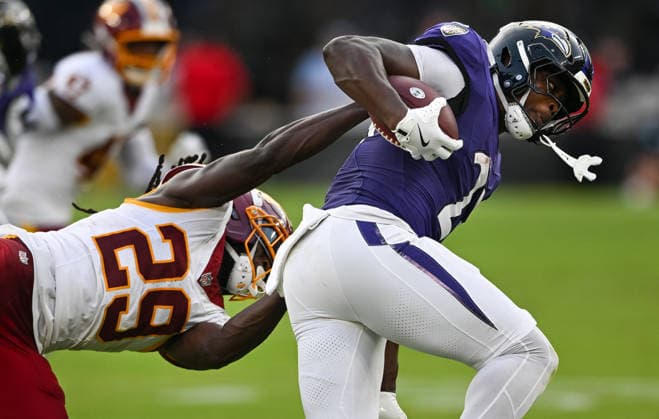 Baltimore Ravens running back Adam Randall (23) runs past Washington Commanders cornerback Darius Rush (29) for a first down during the second quarter of a preseason game at M&T Bank Stadium in Baltimore, Maryland, on Friday, August 28, 2026. The Commanders were also called for a defensive penalty during the play.  BAL20260828111 DAVIDxTULIS