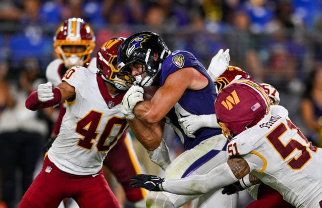 Baltimore Ravens tight end Ty Pezza (84) is stopped by Washington Commanders tight end Quentin Moore (40) and linebacker Ale Kaho (51) during the fourth quarter of a preseason game at M&T Bank Stadium in Baltimore, Maryland, on Friday, August 28, 2026. The Ravens won 41-3.  BAL20260828128 DAVIDxTULIS