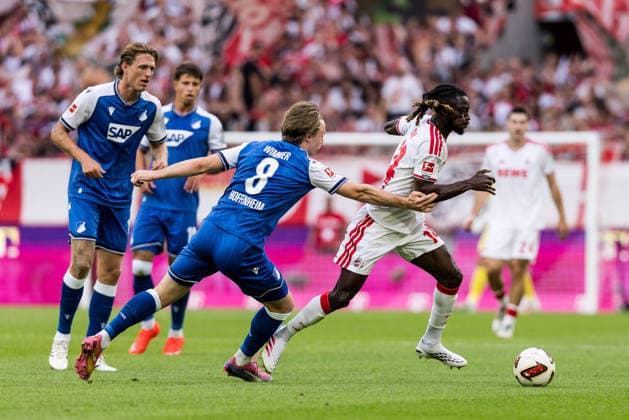 KOELN, GERMANY - AUGUST 29: Gideon Mensah (1. FC Koeln, 14) controls the ball against Patrick Wimmer (TSG 1899 Hoffenheim, 8) during the Bundesliga match between 1. FC Koeln vs. TSG 1899 Hoffenheim at Rheinenergie-Stadion on matchday 1 of the 1. Bundesliga on August 29, 2026 in Koeln, Germany. DFL REGULATIONS PROHIBIT ANY USE OF PHOTOGRAPHS AS IMAGE SEQUENCES AND OR QUASI-VIDEO. North Rhine Westphalia Germany Copyright: xSteffiexWunderlx