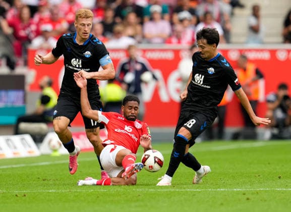 Philipp Mwene (1. FSV Mainz 05, 2) geht zwischen Laurin Curda (SC Paderborn 07, 17) und Laurin Ulrich (SC Paderborn 07, 28) in den Zweikampf. GER, 1. FSV Mainz 05 vs SC Paderborn 07, 1. Bundesliga, 1. Spieltag, Saison 2026-27, MEWA-Arena, Mainz, 29.08.2026 DFL REGULATIONS PROHIBIT ANY USE OF PHOTOGRAPHS AS IMAGE SEQUENCES AND OR QUASI-VIDEO GER, 1. FSV Mainz 05 vs SC Paderborn 07, 1. Bundesliga, 1. Spieltag, Saison 2026-27, 29.08.2026 Mainz *** Philipp Mwene (1, FSV Mainz 05, 2) goes head-to-head with Laurin Curda (SC Paderborn 07, 17) and Laurin Ulrich (SC Paderborn 07, 28) in GER, 1 FSV Mainz 05 vs. SC Paderborn 07, 1 Bundesliga, Matchday 1, 2026–27 season, MEWA Arena, Mainz, August 29, 2026 DFL regulations prohibit any use of photographs as image sequences and or quasi-video GER, 1 FSV Mainz 05 vs. SC Paderborn 07, 1 Bundesliga, Matchday 1, 2026–27 Season, August 29, 2026, Mainz Copyright: xEibner-Pressefoto ScottxColemanx EP_SCN