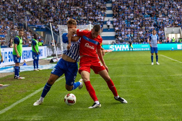 Deutschland: 2.Bundesliga, Saison 2026 2027, 30.08.2026, 3. Spieltag, 1.FC Magdeburg vs Holstein Kiel, Avnet Arena : Torben Muesel (1.FC Magdeburg, 26) im Zweikampf gegen Adrian Kapralik (Holstein Kiel, 20) *** Germany 2. Bundesliga, 2026–2027 Season, August 30, 2026, Matchday 3, 1. FC Magdeburg vs. Holstein Kiel, Avnet Arena: Torben Muesel of 1. FC Magdeburg, No. 26, in a tackle against Adrian Kapralik of Holstein Kiel, No. 20 Copyright: xMichellexLukax