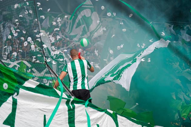 Deutschland: Fussball Bundesliga Saison 2026 - 2027, 1. Spieltag - SC Freiburg vs Werder Bremen - Europa Park Stadion (Freiburg): Fankurve von Werder Bremen im Stadion: Vorsänger mit Megafon vor dicht gedrängten Fans, umgeben von großen grün-weißen Schwenkfahnen. Grüner Rauch, Konfetti und Luftschlangen prägen die Choreographie. Zuschauer, Fans, Ultras, Supporter, Tribüne, Fanblock, Fankultur, Fanchoreo, Choreographie, Fahnenmeer, Megafon, Rauch, Pyrotechnik, Konfetti, Stimmung, Emotionen. *** Germany Soccer Bundesliga 2026–2027 Season, Matchday 1: SC Freiburg vs. Werder Bremen at Europa-Park Stadium in Freiburg. Werder Bremen fan section in the stadium; a lead singer with a megaphone in front of a densely packed crowd of fans, surrounded by large green-and-white waving flags. Green smoke, confetti, and streamers characterize the choreography. Spectators, fans, ultras, supporters, stands, fan section, fan culture, fan choreography, choreography, sea of flags, megaphone, smoke, pyrotechnics, confetti, atmosphere, emotions Copyright: xJOERANxSTEINSIEKx