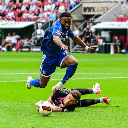 30.08.2026, GER, Fußball, Herren, 1. Bundesliga, FC Augsburg vs FC Schalke 04 Finn Dahmen (FC Augsburg, 1) wirft sich in den Angriff von Moussa Sylla (Schalke, 9) Augsburg WWK-Arena Bayern Deutschland *** August 30, 2026, GER, Soccer, Men s, Bundesliga 1, FC Augsburg vs. FC Schalke 04; Finn Dahmen (FC Augsburg, 1) throws himself into a tackle against Moussa Sylla (Schalke, 9); Augsburg WWK Arena, Bavaria, Germany Copyright: xNordphotox xHafnerx
