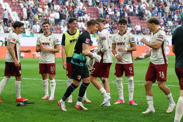 Schlussjubel, die Mannschaft feiert ihren sieg bei der Fankuve, Finn Dahmen 1 (FC Augsburg), Yannik Keitel 14 (FC Augsburg), FC Augsburg vs. FC Schalke 04, Fussball, 1. Bundesliga, 1. Spieltag, 30.08.2026 DFB regulations prohibit any use of photographs as image sequences and or quasi-video Augsburg Bayern Deutschland *** Final celebrations: The team celebrates its victory at the Fankuve; Finn Dahmen (1, FC Augsburg), Yannik Keitel (14, FC Augsburg); FC Augsburg vs. FC Schalke 04; soccer; Bundesliga; Matchday 1, August 30, 2026. DFB regulations prohibit any use of photographs as image sequences and or quasi-video. Augsburg, Bavaria, Germany Copyright: xkolbert-press ChristianxKolbertx