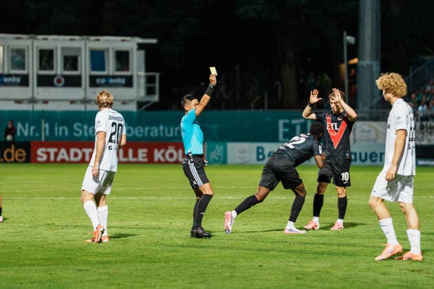 Deutschland: Fußball 3. Liga Männer 2026 - 2027, 3. Spieltag - FC Viktoria Köln vs SC Preußen Münster (Köln): Schiedsrichter Ryo Tanimoto (Japan, FIFA-Referee) zeigt gelbe Karte, Verwarnung gegen Antonio Tikvic (SC Preußen Münster, 4) Copyright: xThiemoxRudolphx