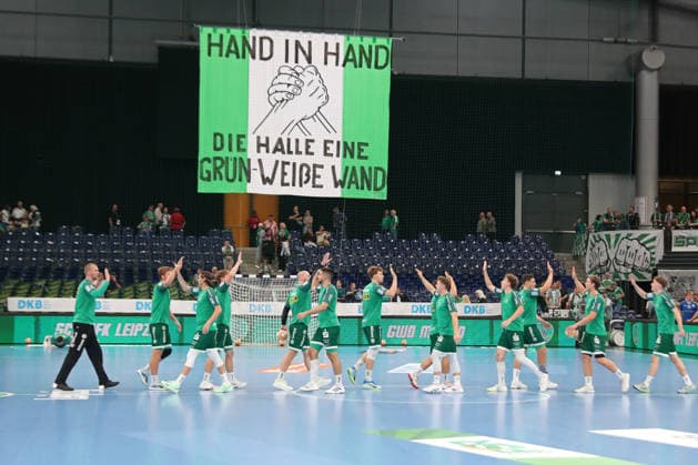 Handball, HBL2: SC DHfK Leipzig - GWD Minden; 31.08.2026 Das Team des SC DHfK Leipzig klatscht sich bei der Erwärmung ab. Über der Mannschaft: Banner Fahne der Fans mit dem Spruch: HAND IN HAND - DIE HALLE EINE GRÜN-WEIßE WAND. Symbolbild, Feature, Zusammenhalt. Handball, 2. Bundesliga, Saison 2026 2027, 1. Spieltag: SC DHfK Leipzig vs. GWD Minden am 31.08.2026 in der Quarterback Immobilien Arena Leipzig. Copyright: xBEAUTIFULxSPORTS JanxKaeferx