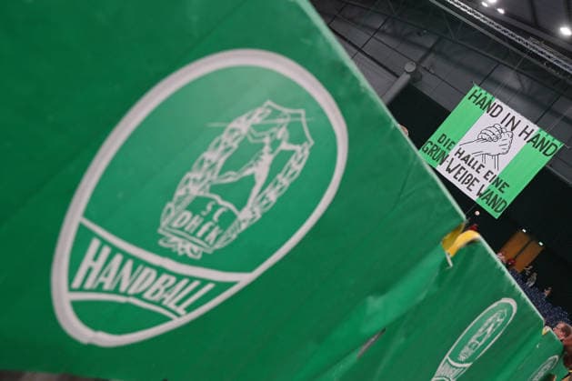 Handball, HBL2: SC DHfK Leipzig - GWD Minden; 31.08.2026 Banner Fahne der Fans mit dem Spruch: HAND IN HAND - DIE HALLE EINE GRÜN-WEIßE WAND. Davor ein großes Wappen des SC DHfK Leipzig. Symbolbild, Feature, Zusammenhalt. Handball, 2. Bundesliga, Saison 2026 2027, 1. Spieltag: SC DHfK Leipzig vs. GWD Minden am 31.08.2026 in der Quarterback Immobilien Arena Leipzig. Copyright: xBEAUTIFULxSPORTS JanxKaeferx