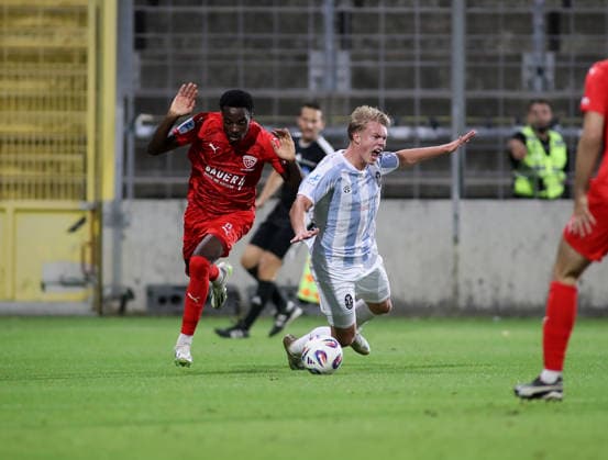 Fussball, Herren, Toto-Pokal, Ahtelfinale, Saison 2026 2027, TSV 1860 München - TSV Buchbach Grünwalder Stadion Daniel Muteba (TSV Buchbach) (li.) foult Fabio Wagner (TSV 1860 München) (re.) im Strafraum, worauf es einen Strafstoss, Elfmeter gab