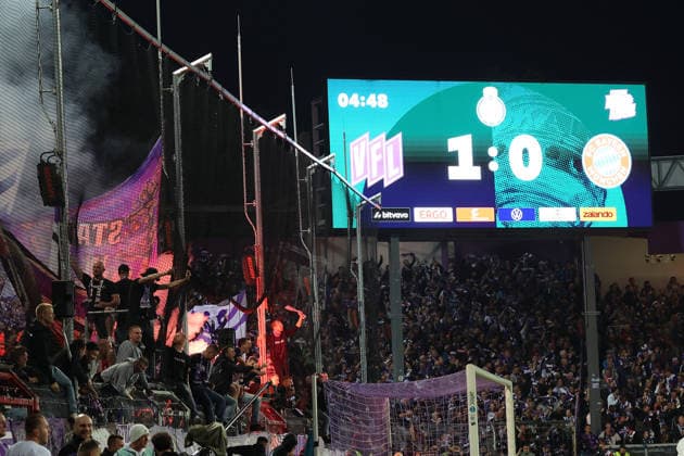 02.09.2026, xrekx, Fussball DFB Pokal 1.Runde, VfL Osnabrueck - FC Bayern München v.l. Fans, Zuschauer, Ultras, Stimmung, Fahnen, Trikots, VC, Violet Crew zuenden Pyrotechnik, Benglos, Rauch, Nebel, Feuerwerk Anzeigetafel Osnabrueck