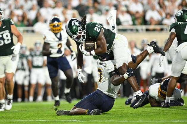 EAST LANSING, MI - SEPTEMBER 04: Michigan State Spartans running back Marvis Parrish (21) delivers a punishing hit to Toledo Rockets safety Armorion Smith (7) during a college football game between the Michigan State Spartans and Toledo Rockets on September 4, 2026 at Spartan Stadium in East Lansing, MI. (Photo by Adam Ruff Icon Sportswire) COLLEGE FOOTBALL: SEP 04 Toledo at Michigan State EDITORIAL USE ONLY Icon260908008