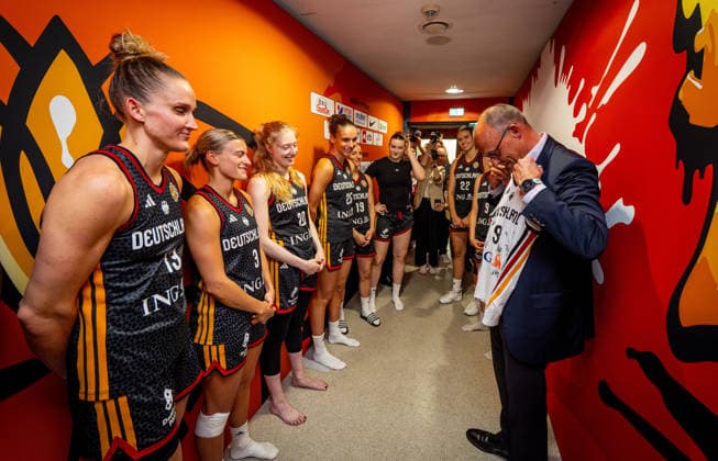Basketball Berlin 04.09.2026 FIBA Women™s Basketball World Cup Germany 2026 Vorrunde Gruppe Spanien (ESP) - Deutschland (GER) Bundeskanzler Friedrich Merz zu Gast Besuch der Deutschen Mannschaft nach dem Spiel vor der Kabine Leonie Fiebich (Deutschland, No.13) überreicht ihm ein unterschriebenes Trikot Alexandra Wilke (Deutschland, No.03) Frida Bühner (Deutschland, No.20) Clara Bielefeld (Deutschland, No.25) und andere