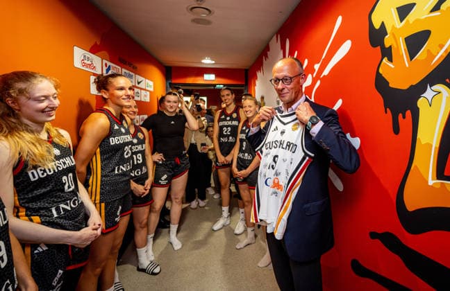 Basketball Berlin 04.09.2026 FIBA Women™s Basketball World Cup Germany 2026 Vorrunde Gruppe Spanien (ESP) - Deutschland (GER) Bundeskanzler Friedrich Merz zu Gast Besuch der Deutschen Mannschaft nach dem Spiel vor der Kabine Leonie Fiebich (Deutschland, No.13) überreicht ihm ein unterschriebenes Trikot Frida Bühner (Deutschland, No.20) Clara Bielefeld (Deutschland, No.25) und andere