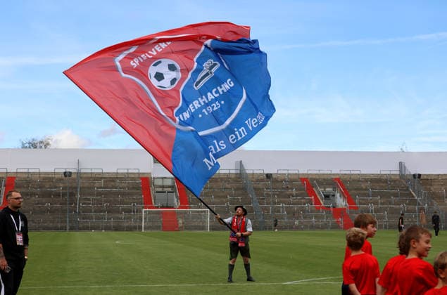 Fussball, Herren, Regionalliga Bayern, Saison 2026 2027, SpVgg Unterhaching - FC Augsburg II, Amateure Ein Fahnenschwenker, Fahne mit dem Logo, Wappen der SpVgg Unterhaching