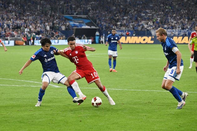 Jamal Musiala (Bayern Muenchen), mi., gegen Satoshi Tanaka (FC Schalke 04), li., rechts Timo Becker (FC Schalke 04) 05.09.2026, Fussball 1. Bundesliga, Saison 2026 2027, 2. Spieltag, FC Schalke 04 - FC Bayern München DFL regulations prohibit any use of photographs as image sequences and or quasi-video Gelsenkirchen Veltins Arena Nordrhein Westfalen Deutschland *** Jamal Musiala, Bayern Munich (center), facing Satoshi Tanaka, FC Schalke 04 (left), with Timo Becker, FC Schalke 04, on the right; May 9, 2026; Soccer, 1. Bundesliga, 2026–2027 season; Matchday 2, FC Schalke 04 vs. FC Bayern Munich. DFL regulations prohibit any use of photographs as image sequences and or quasi-video. Gelsenkirchen, Veltins Arena, North Rhine-Westphalia, Germany Team2