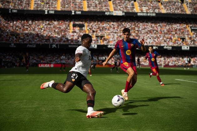 September 6, 2026, Valencia, Alicante, Spain: VALENCIA, SPAIN - SEPTEMBER 6: 27 DAVID OTORBI shoots in front of 18 GERARD MARTIN during the match between Valencia CF and FC Barcelona, Barca from LaLiga EASports, matchweek 4, disputed at the Mestalla Stadium, Valencia Soccer 2026: Levante UD Vs Real Betis  - ZUMAc290 20260906_zsp_c290_019 Copyright: xJordixCantox
