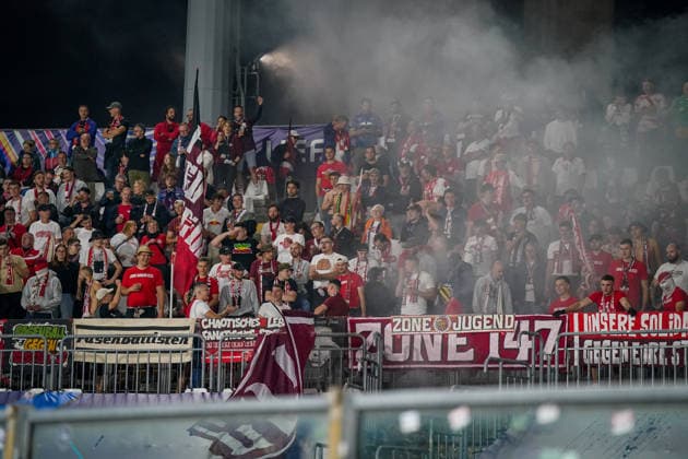 Italien: Fussball UEFA Champions League 2026 - 2027, 1. Spieltag - Como 1907 vs RB Leipzig - Giuseppe Sinigaglia (Como): Fans von RB Leipzig im Gästeblock des Stadions Giuseppe Sinigaglia in Como nach dem Einsatz von Pyrotechnik, dichter Rauch zieht über die Tribüne. Fußball, Champions League, RB Leipzig, Auswärtsfans, Zuschauer, Fans, Gästetribüne, Fanblock, Ultras, Fankultur, Pyrotechnik, Rauch, Fahnen, Banner, Transparente, Spruchbänder, Zone 147, Stimmung. Copyright: xJOERANxSTEINSIEKx
