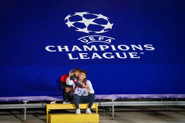 Italien: Fussball UEFA Champions League 2026 - 2027, 1. Spieltag - Como 1907 vs RB Leipzig - Giuseppe Sinigaglia (Como): Junger Fan und Begleitperson machen ein Selfie vor großem UEFA-Champions-League-Logo im Stadion Giuseppe Sinigaglia in Como. Fußball, Champions League, UEFA, Fan, Kind, Selfie, Smartphone, Erinnerung, Erlebnis, Zuschauer, Stadion, Sportstätte, Branding, Logo, Europapokal, Como, Italien, Fankultur, Generationen. Copyright: xJOERANxSTEINSIEKx