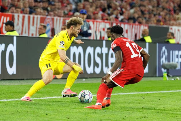 Ole Didrik Blomberg (11, FK Bodo Glimt) und Alphonso Davies (19, FC Bayern München) beim Spiel zwischen FC Bayern München v FK Bodo Glimt, Fussball, Herren, UEFA Champions League, 2026 2027, 1.Spieltag am 10.09.2026 in München, Allianz Arena. Bayern Deutschland
