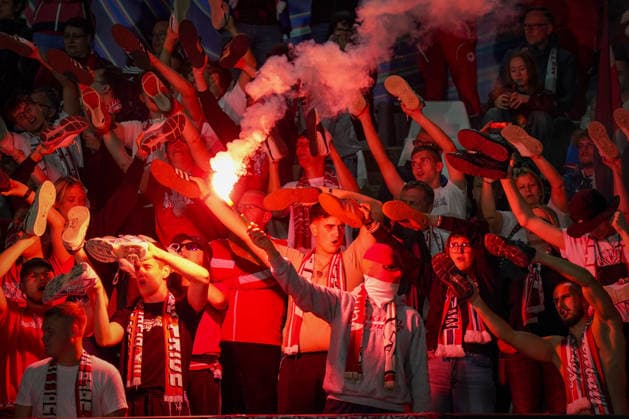Italien: Fussball UEFA Champions League 2026 - 2027, 1. Spieltag - Como 1907 vs RB Leipzig - Giuseppe Sinigaglia (Como): Fans von RB Leipzig im Gästeblock halten bei einer Choreographie ihre Schuhe in die Höhe, während ein Fan Pyrotechnik Bengalo zündet. Fußball, Champions League, RB Leipzig, Auswärtsfans, Zuschauer, Fans, Ultras, Fankultur, Fanchoreo, Choreographie, Pyrotechnik, Bengalo, Rauch, Gästetribüne, Fanblock, Stimmung, Emotionen. Copyright: xJOERANxSTEINSIEKx