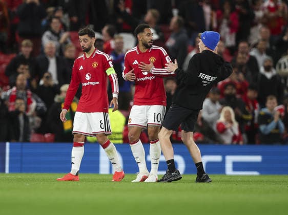 Manchester United, ManU v Sabah, UEFA Champions League, League Stage 10.09.26 Manchester United v Sabah, UEFA Champions League, League Stage Bradley Ormesher The Times pitch Invader on Pitch at end of the match with Bruno Fernandez and Matheus Cunha of Manchester United  Copyright: xBradleyxOrmesherx NINTCHDBPICT001107219819