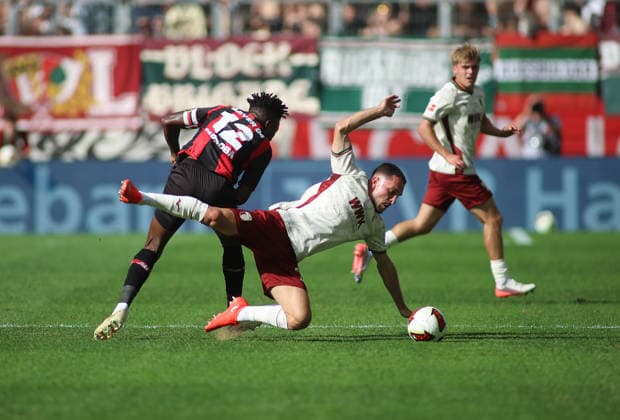Fussball, Herren, Saison 2026 2027, FC Augsburg - Bayer 04 Leverkusen, Bundesliga, WWK Arena Edmond Tapsoba (Bayer 04 Leverkusen) (li.) foult Arijon Ibrahimovic (FC Augsburg) (re.) in einem Zweikampf um den Ball DFL DFB regulations prohibit any use of photographs as image sequences and or quasi-video *** Soccer, Men s, 2026–2027 Season, FC Augsburg vs. Bayer 04 Leverkusen, Bundesliga, WWK Arena: Edmond Tapsoba of Bayer 04 Leverkusen fouls Arijon Ibrahimovic of FC Augsburg during a tackle for the ball. DFL and DFB regulations prohibit any use of photographs as image sequences and or quasi-video.