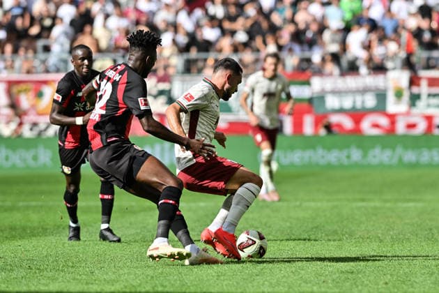 1. Fussball Bundesliga: FC Augsburg - Bayer 04 Leverkusen, 12.09.2026 AUGSBURG, GERMANY; 12. SEPTEMBER: im Duell Edmond TAPSOBA (Bayer Leverkusen 12) und Arijon IBRAHIMOVIC (FC Augsburg 21) während dem Match der Bundesliga zwischen dem FC Augsburg und Bayer 04 Leverkusen am 3. Spieltag in der WWK-Arena DFL REGULATIONS PROHIBIT ANY USE OF PHOTOGRAPHS AS IMAGE SEQUENCES AND OR QUASI-VIDEO *** 1 Bundesliga: FC Augsburg vs. Bayer 04 Leverkusen, September 12, 2026, AUGSBURG, GERMANY, September 12: Edmond TAPSOBA of Bayer Leverkusen (No. 12) and Arijon IBRAHIMOVIC of FC Augsburg (No. 21) face off during the Bundesliga match between FC Augsburg and Bayer 04 Leverkusen on Matchday 3 at the WWK Arena. DFL REGULREGULATIONS PROHIBIT ANY USE OF PHOTOGRAPHS AS IMAGE SEQUENCES AND OR QUASI-VIDEO Copyright: xBEAUTIFULxSPORTS Goldbergx