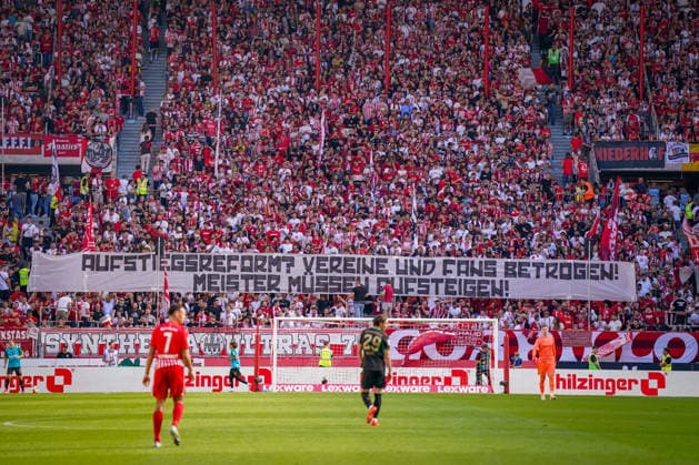 Deutschland: Fussball Bundesliga 2026 - 2027, 3. Spieltag - SC Freiburg vs Borussia Mönchengladbach - Europa-Park-Stadion (Freiburg): Fans des SC Freiburg auf voll besetzter Tribüne mit großem Spruchband Aufstieg reform? Vereine und Fans betrogen! Meister müssen aufsteigen!. Fanprotest, Aufstiegsreform, Regionalliga, Aufstiegsregelung, DFB, Fußball, Fans, Ultras, Zuschauer, Fankurve, Transparent, Spruchband, Protestbanner, Stadion, SC Freiburg. *** Germany Soccer Bundesliga 2026–2027, Matchday 3: SC Freiburg vs. Borussia Mönchengladbach at Europa-Park Stadium in Freiburg. SC Freiburg fans in a packed stands holding a large banner reading: Promotion Reform—Clubs and Fans Betrayed—Champions Must Be Promoted. Fan protest, promotion reform, Regionalliga, promotion rules, DFB, soccer, fans, ultras, spectators, fan section, banner, protest banner, stadium, SC Freiburg Copyright: xJOERANxSTEINSIEKx