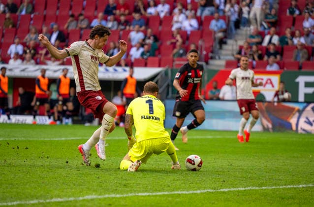 12.09.2026, Fussball Bundesliga 2026 2027, 3.Spieltag, FC Augsburg - Bayer Leverkusen, in der WWK-Arena Augsburg, Torschuss zum 1:1 von Michael Gregoritsch (FC Augsburg) gegen Torwart Mark Flekken (Leverkusen) der den Ball durchrutschen lässt. ***DFL and DFB regulations prohibit any use of photographs as image sequences and or quasi-video.*** *** September 12, 2026, 2026–2027 Bundesliga, Matchday 3, FC Augsburg vs. Bayer Leverkusen, at the WWK Arena in Augsburg, Michael Gregoritsch of FC Augsburg takes a shot that ties the game at 1–1 against Leverkusen goalkeeper Mark Flekken, who lets the ball slip through his hands ***DFL and DFB regulations prohibit any use of photographs as image sequences and or quasi-video***