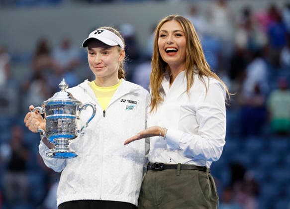Elena Rybakina of Kazakhstan holds the championship trophy standing next to past champion Maria Sharapova after defeating Aryna Sabalenka of Belarus in the Women s Finals match in Arthur Ashe Stadium at the 2026 US Open Tennis Championship at the USTA Billie Jean King National Tennis Center in New York City on Saturday, September 12, 2026. Rybakina won with a score of 6-4, 5-7, 6-2.  NYP20260913005 JOHNxANGELILLO