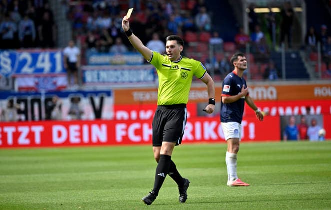 Schiedsrichter Referee Justin Hasmann zeigt Jonas Therkelsen Holstein Kiel (10) (nicht im Bild) gelbe Karte gelb Verwarnung fuer Foul an Michael Heule 1. FC Heidenheim 1846 FCH (27) (nicht im Bild) 1. FC Heidenheim 1846 FCH vs Holstein Kiel KSV 13.09.2026 DFL REGULATIONS PROHIBIT ANY USE OF PHOTOGRAPHS AS IMAGE SEQUENCES AND OR QUASI-VIDEO 1. FC Heidenheim 1846 FCH vs Holstein Kiel KSV