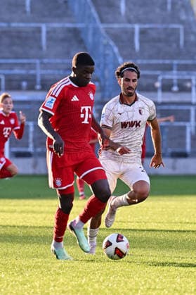 Regionalliga Bayern; FC Bayern München II - FC Augsburg II; 15.09.2026 MUNICH, GERMANY; 15. SEPTEMBER: im Duell Bastian ASSOMO (FC Bayern München II 9) und Nick RASOULINA (FC Augsburg II 21) während dem Match der Regionalliga Bayern zwischen den Amateuren des FC Bayern und dem FC Augsburg II am 9. Spieltag im Grünwalder Stadion Copyright: xBEAUTIFULxSPORTS Goldbergx