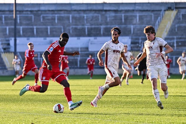 Regionalliga Bayern; FC Bayern München II - FC Augsburg II; 15.09.2026 MUNICH, GERMANY; 15. SEPTEMBER: im Duell Bastian ASSOMO (FC Bayern München II 9) und Nick RASOULINA (FC Augsburg II 21) und Till Sebastian SCHUMACHER (FC Augsburg II 33) während dem Match der Regionalliga Bayern zwischen den Amateuren des FC Bayern und dem FC Augsburg II am 9. Spieltag im Grünwalder Stadion Copyright: xBEAUTIFULxSPORTS Goldbergx