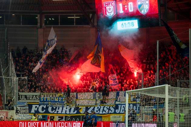 Regionalliga Nordost -Saison 26 27 Hallescher FC vs.FC Carl Zeiss Jena Halle, Deutschland 15.September 2026: Im Bild:Fanblock Jena Feuer, Rauch, Bengali, Bengalis, bengalisches Feuer, zünden, zuenden Feuerwerk, Rauchbombe, Halle Saale Leuna Chemie Stadion Sachsen-Anhalt Deutschland