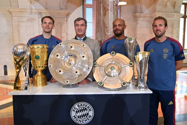 v.li:Manuel NEUER (Torwart Bayern Muenchen), Markus SOEDER (Ministerpraesident Bayern und CSU Vorsitzender), Trainer Vincent KOMPANY (Bayern Muenchen) und Harry KANE (Bayern Muenchen) stehen hinter den gewonnenen Pokalen,Pokal,Cup,Trophaee der Saison 2025 26 ,Meisterschale,Schale,DFB Pokal,Super Cup. Markus SOEDER (Ministerpraesident Bayern und CSU Vorsitzender) empfaengt die Meistermannschaften des FC Bayern Muenchen im Kuppelsaal in der Staatskanzlei in Muenchen am 16.09.2026.