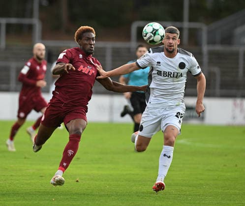 16.09.2026, xophax, Fussball 3.Liga, Fortuna Koeln - SV Wehen Wiesbaden v.l. Romeo Aigbekaen ( Fortuna Köln ) und Jordy Steven Gillekens ( Wehen Wiesbaden ) , rechts Koeln