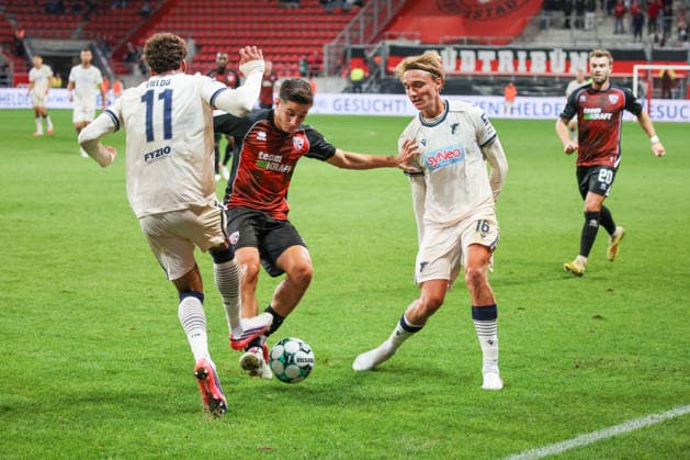 Emre Guel (FC Ingolstadt 04, Nr.5) setzt sich hier gegen Luis Engelns (TSG Hoffenheim II, Nr.16) und Jykese Fields (TSG Hoffenheim II, Nr.11) beim Spiel FC Ingolstadt 04 gegen TSG Hoffenheim II am 16.09.2026, DFB regulations prohibit any use of photographs as image sequences and or quasi-video. GER, Fussball, 3. Liga, Spieltag 6, FC Ingolstadt 04 gegen TSG Hoffenheim II, 16.09.2026, Audi Sportpark Ingolstadt Copyright: xEibner-Pressefoto OliverxSTRISCHx EP-OSH