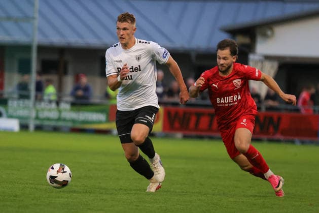 18.09.2026, Fussball, Herren, Saison 2026 2027, Regionalliga Bayern, 10. Spieltag: TSV Buchbach - FC Schweinfurt 05 Von links: Kevin Frisorger (FC Schweinfurt 05, 04) vor Tobias Heiland (TSV Buchbach, 10) Buchbach SMR-Arena Bayern Deutschland