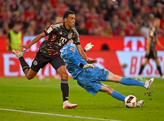 18.09.2026, Fussball Bundesliga 2026 2027, 4.Spieltag, FC Bayern München - 1.FC Union Berlin, in der Allianz-Arena München, Jamal Musiala (Bayern München) gegen Torwart Frederik Rönnow (Union Berlin)