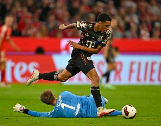 18.09.2026, Fussball Bundesliga 2026 2027, 4.Spieltag, FC Bayern München - 1.FC Union Berlin, in der Allianz-Arena München, Jamal Musiala (Bayern München) gegen Torwart Frederik Rönnow (Union Berlin)