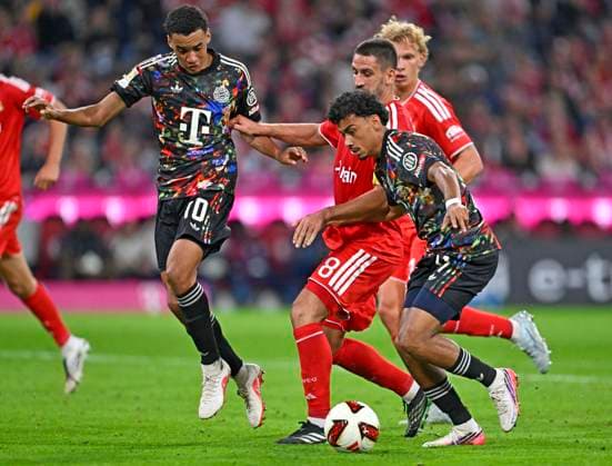 18.09.2026, Fussball Bundesliga 2026 2027, 4.Spieltag, FC Bayern München - 1.FC Union Berlin, in der Allianz-Arena München, v.l. Jamal Musiala (Bayern München), Rani Khedira (Union Berlin) und Nathaniel Brown (FC Bayern München)