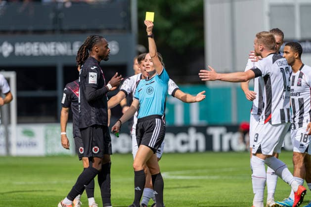 Yannick Tonye (Viktoria Köln, 07) bekommt die Gelbe Karte nach dem Handspiel von Fabienne Michel (Schiedsrichterin), Lars Lokotsch (FC Ingolstadt 04, 13) protestiert, Keanan Bennetts (FC Ingolstadt 04, 18) FC Viktoria Köln vs. FC Ingolstadt 04, Fussball, 3.Liga, 7.Spieltag, Saison 2026 27, 19.09.2026, DFL REGULATIONS PROHIBIT ANY USE OF PHOTOGRAPHS AS IMAGE SEQUENCES AND OR QUASI-VIDEO, FC Viktoria Köln vs. FC Ingolstadt 04, Fussball, 3.Liga, 7.Spieltag, Saison 2026 27, 19.09.2026 Köln Copyright: xEibner-Pressefoto LukasxBaldygax EP_LBA