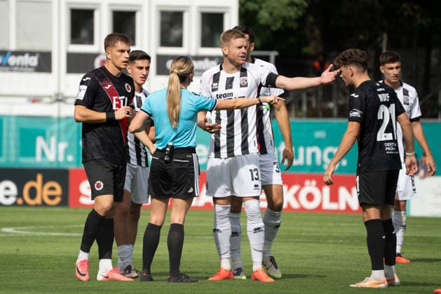 Deutschland: Fussball, 3. Liga, 2026 27, 7. Spieltag, 19.09.2026: FC Viktoria Köln vs. FC Ingolstadt 04: Sportpark Höhenberg (Köln): Schiedsrichterin Fabienne Michel zeigt Lars Lokotsch (FC Ingolstadt 04, 13) , Lucas Wolf (FC Viktoria Köln, 21) und David Otto (FC Viktoria Köln, 10) die Abseitsposition Köln Deutschland Copyright: xMijoxLubecx