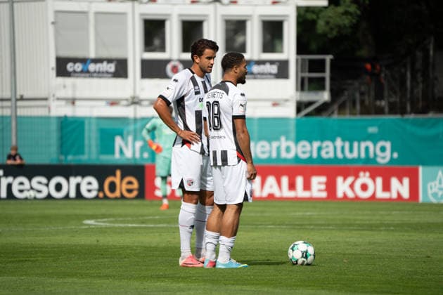 Deutschland: Fussball, 3. Liga, 2026 27, 7. Spieltag, 19.09.2026: FC Viktoria Köln vs. FC Ingolstadt 04: Sportpark Höhenberg (Köln): Keanan Bennetts (FC Ingolstadt 04, 18) und Fredrik Carlsen (FC Ingolstadt 04, 8) richten sich zum Freistoß auf Köln Deutschland Copyright: xMijoxLubecx