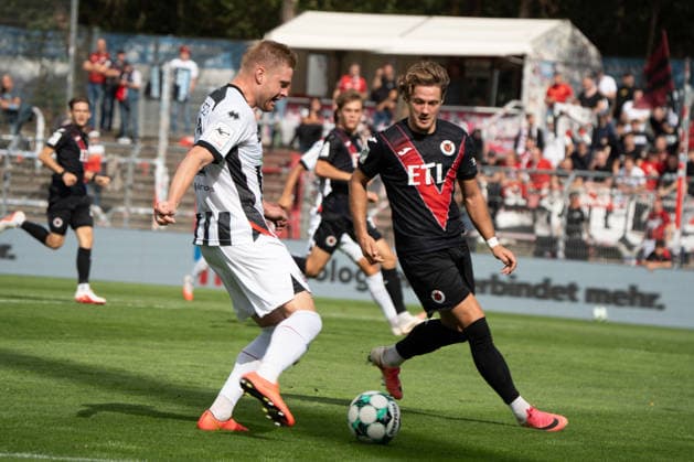 Deutschland: Fussball, 3. Liga, 2026 27, 7. Spieltag, 19.09.2026: FC Viktoria Köln vs. FC Ingolstadt 04: Sportpark Höhenberg (Köln): Lars Lokotsch (FC Ingolstadt 04, 13) flankt den Ball während Tim Kloss (FC Viktoria Köln, 18) versucht den Ball zu blocken Köln Deutschland Copyright: xMijoxLubecx