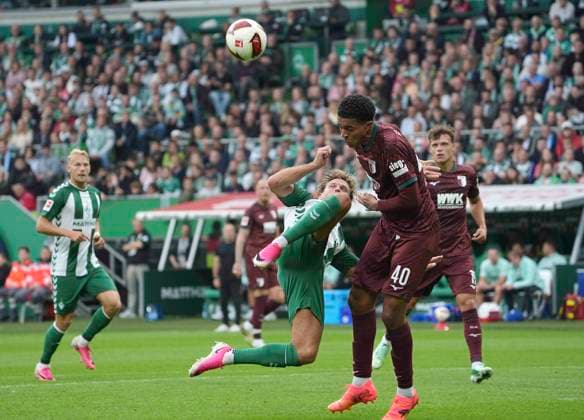 Foto : Niclas FÜLLKRUG (Werder , links) mit Fallrückzieher gegen Noahkai Banks (Augsburg) Fussball 1. Bundesliga , 30. Spieltag am Sa. 18.04.2026 Werder Bremen - Hamburger SV