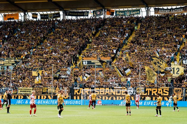 Deutschland: Fussball 3. Liga 2026 - 2027, 7. Spieltag - Alemannia Aachen vs Fortuna Düsseldorf - Tivoli (Aachen): Schals oben auf Werner Fuchs Tribüne, You ll never walk alone, Support, ausverkauft, Ultras Copyright: xThiemoxRudolphx