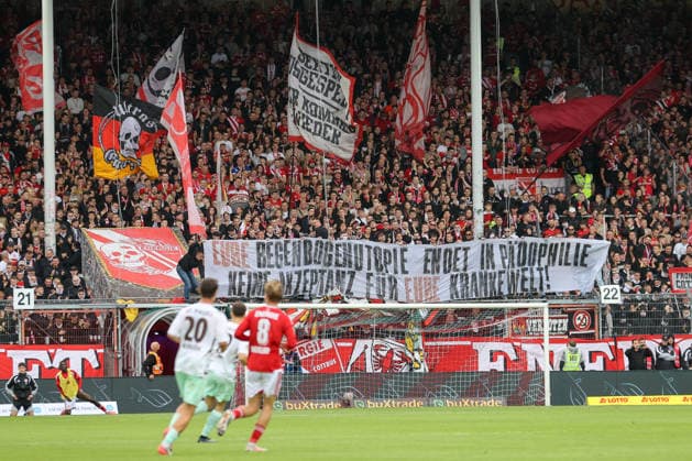 20.09.2026, xtgx, Fussball 2. Bundesliga, FC Energie Cottbus - FC St. Pauli, v.l. Symbolfoto, Symbolbild, Symbol Fans, Zuschauer, Publikum, Tribuene Spruchband Banner Eure Regenbogenutopie endet in Pädophilie. Keine Akzeptanz für eure kranke Welt (DFL DFB REGULATIONS PROHIBIT ANY USE OF PHOTOGRAPHS as IMAGE SEQUENCES and or QUASI-VIDEO) Cottbus