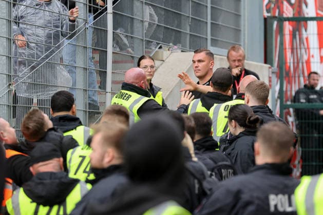 20.09.2026, xtgx, Fussball 2. Bundesliga, FC Energie Cottbus - FC St. Pauli, v.l. Ordner und Polizisten entfernen Personen aus dem Stadion, die versucht hatten, durch den Innenraum zum Gästeblock zu gelangen (DFL DFB REGULATIONS PROHIBIT ANY USE OF PHOTOGRAPHS as IMAGE SEQUENCES and or QUASI-VIDEO) Cottbus