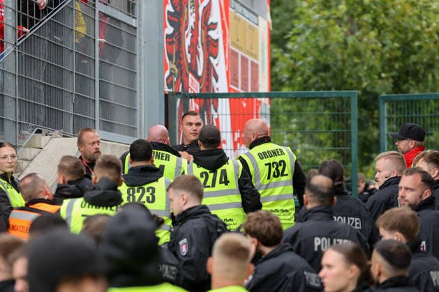 20.09.2026, xtgx, Fussball 2. Bundesliga, FC Energie Cottbus - FC St. Pauli, v.l. Ordner und Polizisten entfernen Personen aus dem Stadion, die versucht hatten, durch den Innenraum zum Gästeblock zu gelangen (DFL DFB REGULATIONS PROHIBIT ANY USE OF PHOTOGRAPHS as IMAGE SEQUENCES and or QUASI-VIDEO) Cottbus